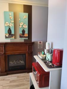 a living room with a fireplace and a microwave at Petit Hôtel Amara in La Malbaie +84 photos