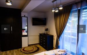 a bedroom with a bed and a dresser and a window at Apartament Kalinderu K2 Busteni in Buşteni