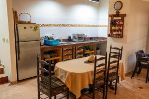 a kitchen with a table and a refrigerator at The Mexican in Los Altos de Cerro Azul