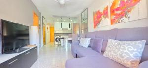 a living room with a purple couch and a tv at AYF PLAYA MORRO DE GOS in Oropesa del Mar
