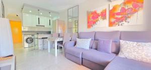 a living room with a purple couch and a kitchen at AYF PLAYA MORRO DE GOS in Oropesa del Mar