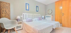 a bedroom with a white bed and a white chair at AYF PLAYA MORRO DE GOS in Oropesa del Mar +36 photos