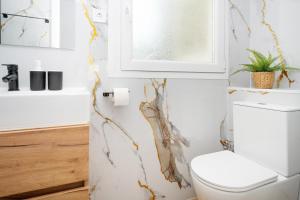 a bathroom with a white toilet and a window at Bright Renovated 2BR Apt- Balcony - Beach 10' Walk - Barcelona 25' Train in Sant Adria de Besos