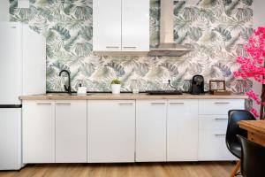 a kitchen with white cabinets and a floral wallpaper at Bright Renovated 2BR Apt- Balcony - Beach 10' Walk - Barcelona 25' Train in Sant Adria de Besos +7 photos