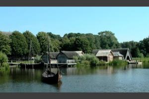 a boat sitting in the water next to some buildings at Monteurzimmer Oldenburg i.H. – Top Lage in Oldenburg in Holstein +4 photos