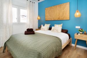 a bedroom with a large bed with blue walls at Bright Renovated 2BR Apt- Balcony - Beach 10' Walk - Barcelona 25' Train in Sant Adria de Besos