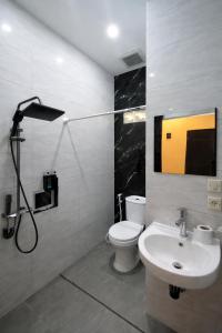 a bathroom with a white toilet and a sink at Bakom Inn Syariah in Bogor +51 photos