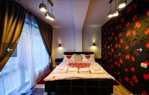 a bedroom with a large bed with a floral wall at Apartament Kalinderu K2 Busteni in Buşteni