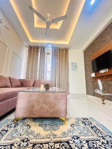 a living room with a couch and a ceiling fan at Sukhhin Chandigarh in Zirakpur