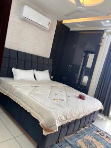 a bedroom with a large bed with a black headboard at Sukhhin Chandigarh in Zirakpur