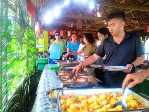 a group of people preparing food at a buffet at Amazon Bromelia Lodge & Expeditions in Iquitos