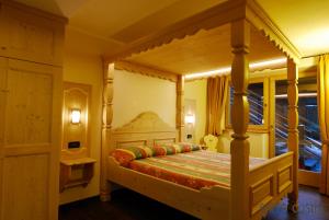 a bedroom with a four poster bed with a canopy at Residence Baita Cusini in Livigno