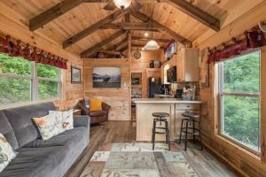 a living room and kitchen in a tiny house at Cedar Heights Tiny House Log Cabin in Bryson City