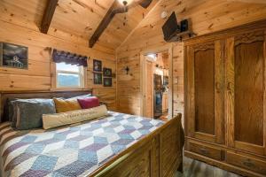 a bedroom with a bed in a wooden cabin at Cedar Heights Tiny House Log Cabin in Bryson City