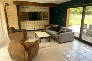 a living room with couches and chairs and a tv at La Maison de Fougerolles, Renovated farmhouse in Fougerolles