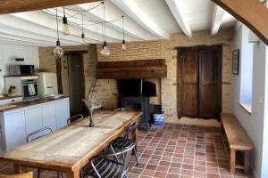 a kitchen with a wooden table in a room at La Maison de Fougerolles, Renovated farmhouse in Fougerolles