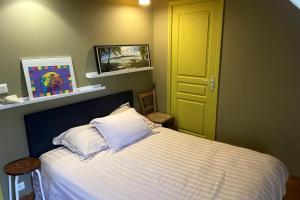 a bedroom with a bed and a yellow door at La Maison de Fougerolles, Renovated farmhouse in Fougerolles +12 photos