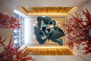 a painting on a wall in a room with flowers at Conrad Hamburg in Hamburg