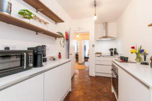 a kitchen with white cabinets and a microwave at Cobb's Margate Old Town Hideaway in Margate
