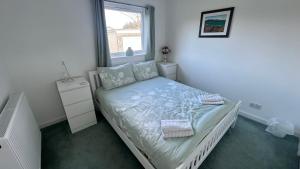 a small bedroom with a bed and a window at 3 bedroom cottage in Lamlash
