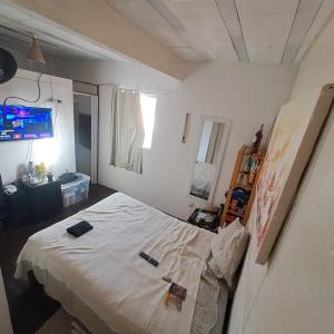 a bedroom with a bed and a tv on the wall at Casa Valhalla Pipa in Pipa