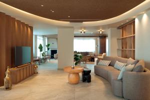 a living room with a couch and a tv at Zeus Eleva Kassandra Lagoon in Hanioti