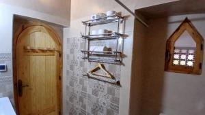 a bathroom with a door and a wall with shelves at La Colline Verte Dar Ait El Abass in Ouarzazate +87 photos