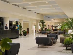 a lobby of a hotel with chairs and plants at H10 Berlin Ku'Damm in Berlin +100 photos