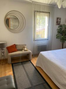 a bedroom with a bed and a chair and a mirror at la passerelle du couchant in Langlade +20 photos