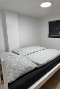 a bed in a white room with a white wall at Comfy House Privé in Erftstadt