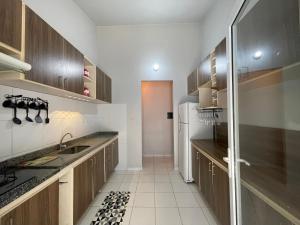 a kitchen with wooden cabinets and a white refrigerator at Aeroporto Manaus in Manaus
