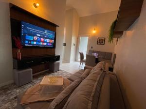 a living room with a couch and a flat screen tv at Aeroporto Manaus in Manaus