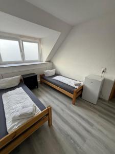 two beds in a room with two windows at K 357 - Low budget Hotel in Ratekau bei Lübeck in Ratekau