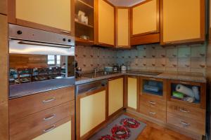 a kitchen with wooden cabinets and a sink at Affittacamere ai 4 venti in Arta Terme