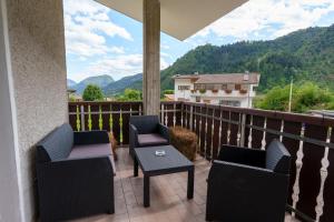 a balcony with chairs and a table and mountains at Affittacamere ai 4 venti in Arta Terme