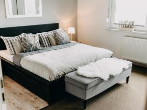 a bedroom with a large bed with a ottoman at Hillside Braunlage in Braunlage