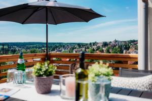 a table with an umbrella and bottles of wine on a balcony at Hillside Braunlage in Braunlage