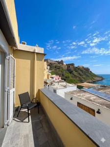 a chair on a balcony with a view of the ocean at Nonna Liberina in Procida