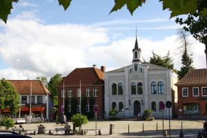 a white building with a steeple on top of it at Zentrale Monteurwohnung in Oldenburg i H in Oldenburg in Holstein