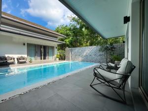a patio with a swimming pool and chairs next to a house at Luxury 3BR Pool Villa Private Pool Quiet Area in Ban Klang