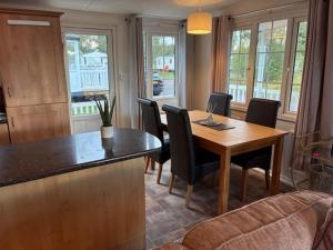 a kitchen with a dining room table and chairs at Bramble Lodge in West Chevington