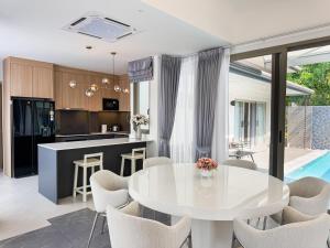 a kitchen and living room with a white table and chairs at Luxury 3BR Pool Villa Private Pool Quiet Area in Ban Klang