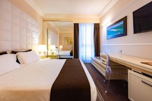 a hotel room with a large bed and a desk at Etrusco Arezzo Hotel - Sure Hotel Collection by Best Western in Arezzo +94 photos