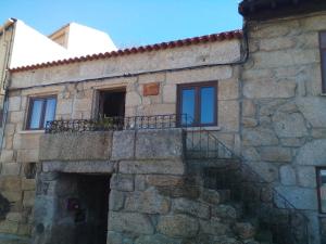 un edificio de piedra con balcón en la parte superior. en Casa Marias, en Belmonte