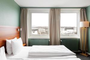 ein Hotelzimmer mit einem Bett und zwei Fenstern in der Unterkunft Best Western Hotel Sverre in Sandnes