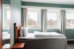 ein Schlafzimmer mit zwei Fenstern und einem Bett mit weißer Bettwäsche in der Unterkunft Best Western Hotel Sverre in Sandnes