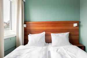 Ein Schlafzimmer mit zwei Betten mit weißer Bettwäsche und einem hölzernen Kopfteil in der Unterkunft Best Western Hotel Sverre in Sandnes
