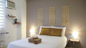 a bedroom with a large white bed with two lamps at Park View Hostel & Suites in Manta