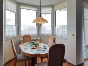 a dining room with a table and chairs and a chandelier at FeWo Krüger 17 in Dahme