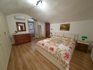 a bedroom with a large bed and a dresser and a window at Dammuso Nuzzarè in Syracuse